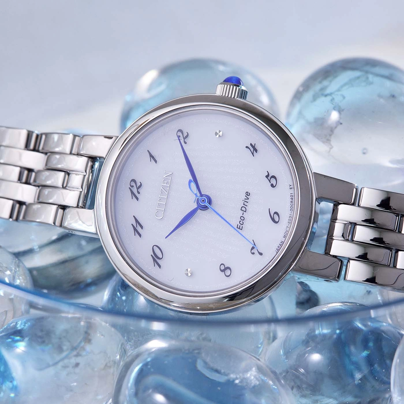 Citizen Eco-Drive -kello, jossa siniset osoittimet ja hopeinen ranneke lasihelmillä.