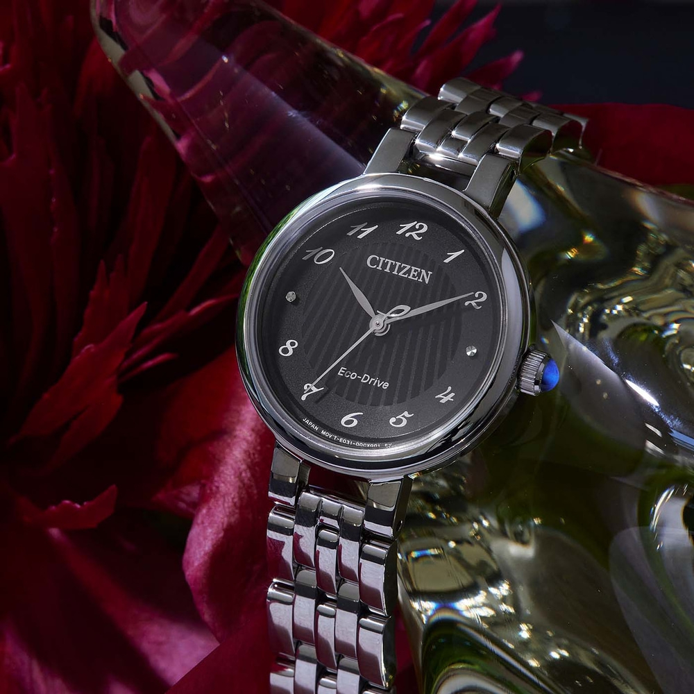 Citizen-kello, jossa musta kellotaulu, hopeinen ranneke ja Eco-Drive-tekniikka.