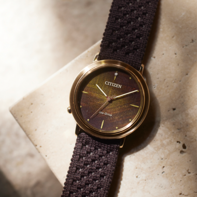 Citizen-kello ruskealla rannekkeella ja kultaisella kellotaululla, Eco-Drive.