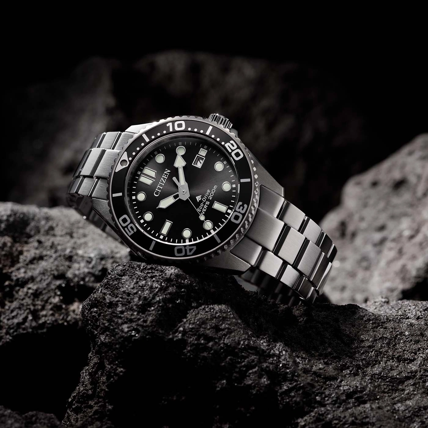 Citizen-kello kivellä. Musta kellotaulu, hopeinen ranneke. Eco-Drive, sukeltajat 200m.