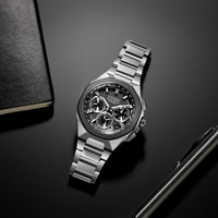 Citizen-kello mustalla pinnalla kynän ja muistikirjan kanssa.