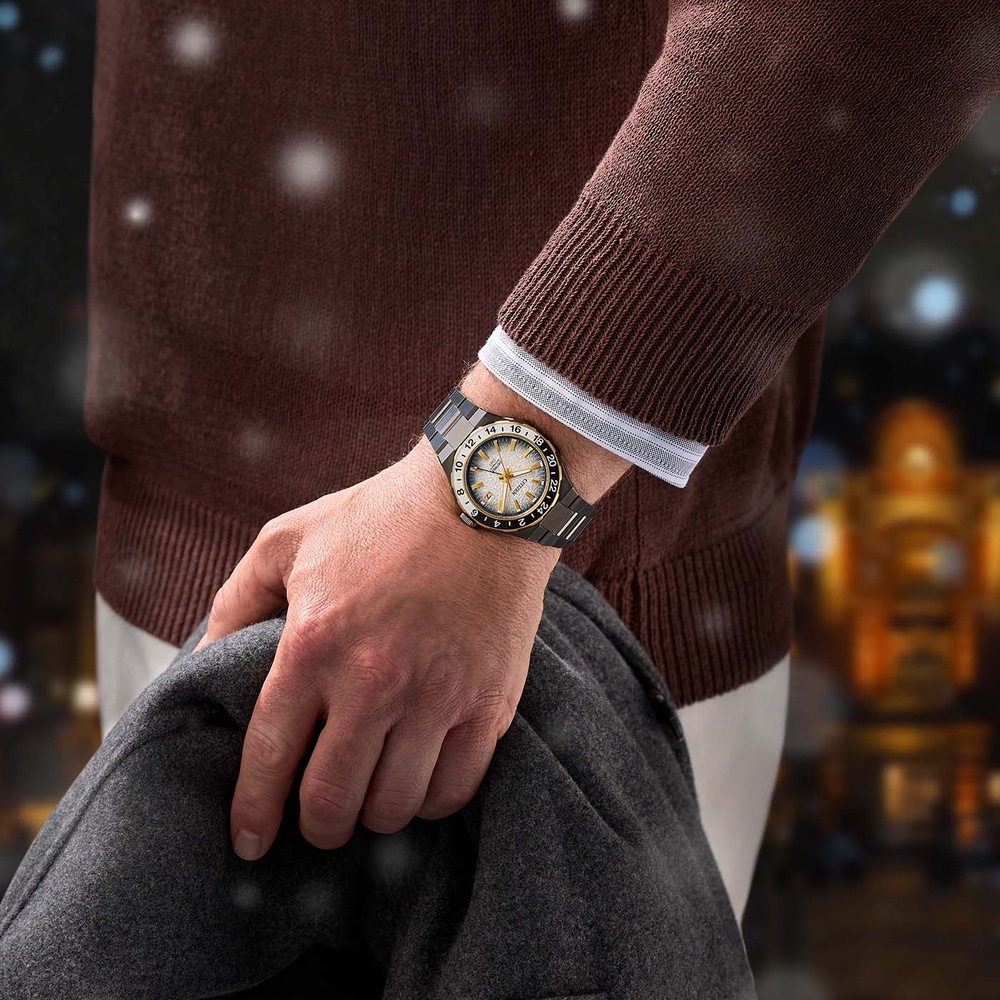 Mies, jolla on kello, takki kädessä, sumea tausta, talvivaatteet.