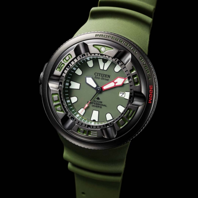 Citizen Eco-Drive -kello vihreällä rannekkeella ja kellotaululla, musta tausta, lähikuva.