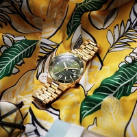 Kultainen Citizen-kello keltaisella kukkapaidalla.
