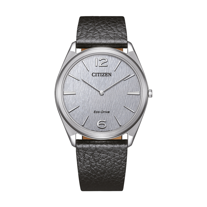 Citizen-kello hopeisella kellotaululla ja mustalla nahkahihnalla vihreällä taustalla