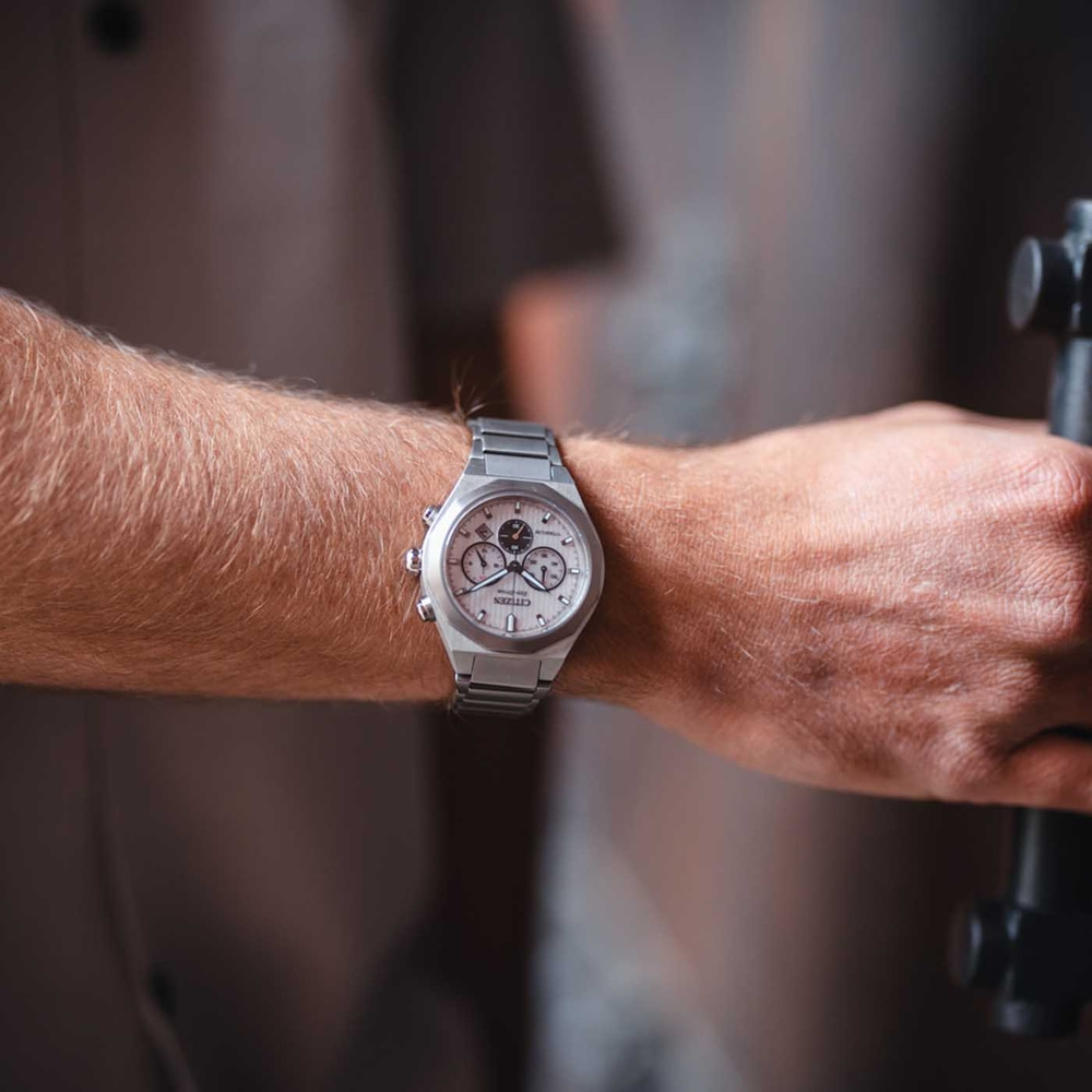 Lähikuva henkilön ranteesta, jossa on hopeinen Citizen-kello.