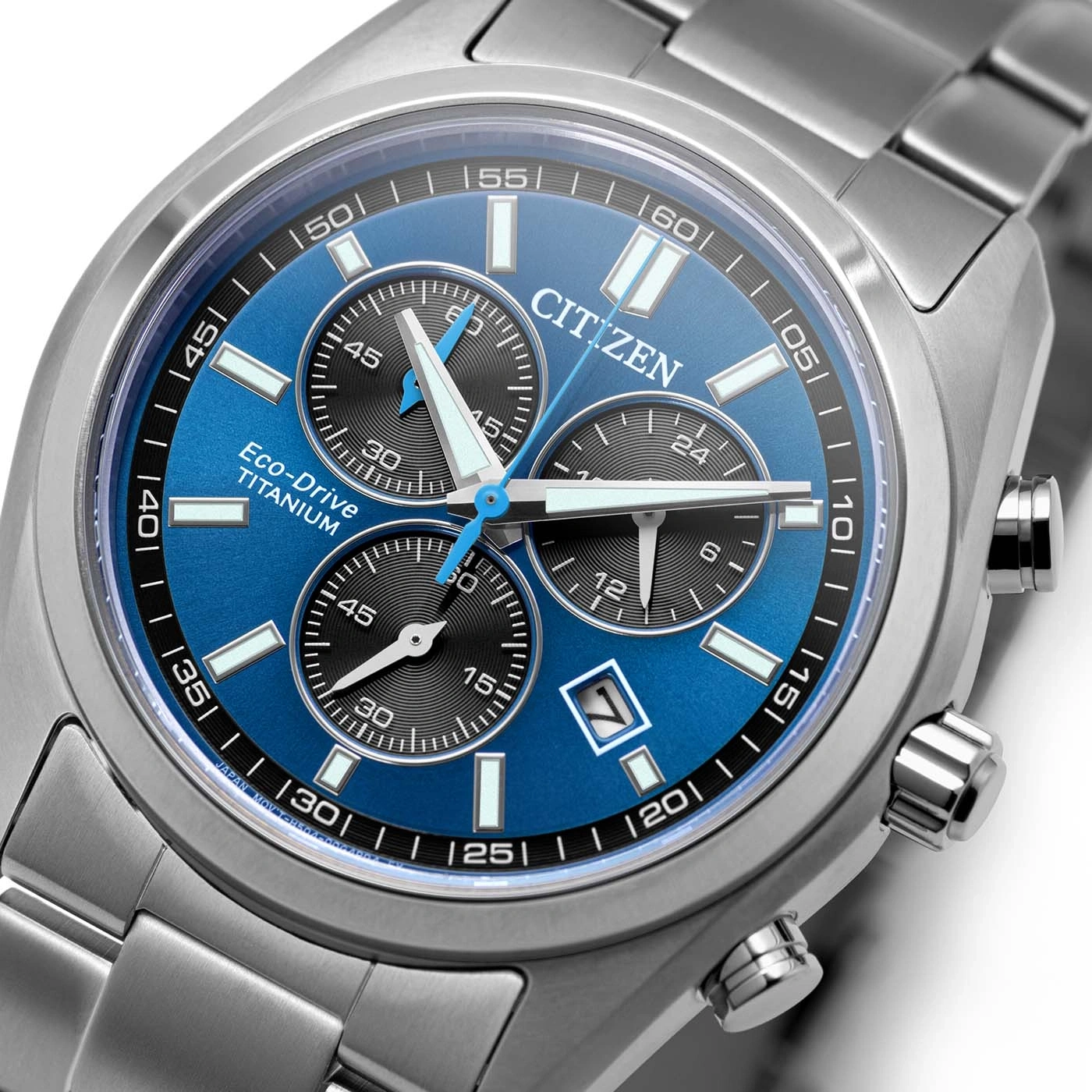 Lähikuva sinisestä Citizen Eco-Drive Titanium -kellotaulusta kronografin pienoismalleilla.