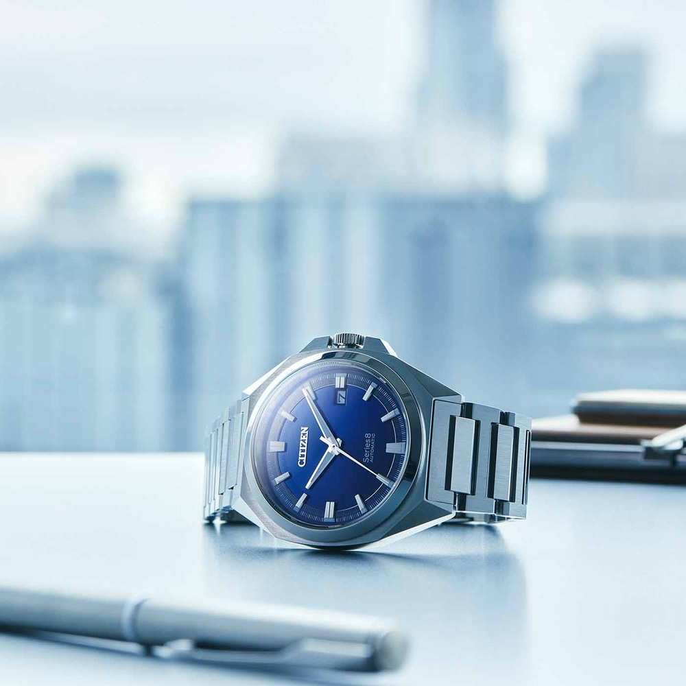 Citizen Series 8 -kello, jossa sininen kellotaulu pöydällä ja kynä.