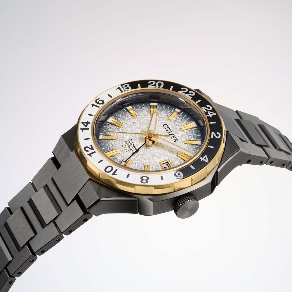 Citizen-kello, jossa on kultaiset yksityiskohdat ja kuvioitu hopeinen kellotaulu, musta ranneke.